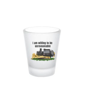 May include: White shot glass featuring the text "I am willing to be unreasonable" and a cartoon image of a yellow bulldozer.