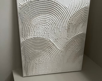 May include: White canvas painting with a textured, raised design of overlapping circles in a wave pattern.