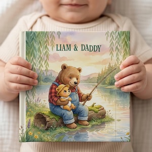 May include: A children's book with the text "LIAM & DADDY" on the cover. The illustration depicts a bear fishing with a smaller bear. The bears are sitting on a log near a lake. The background shows trees and mountains.