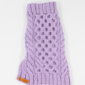 May include: A lavender knitted dog sweater with a cable knit pattern and a small brown leather tag that says "Imari's Place".