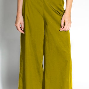 Puede incluir: Un pantalón de pierna ancha de color amarillo mostaza. El pantalón tiene un diseño de envoltura y un lazo en la cintura.