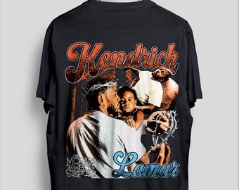 Op de afbeelding: Een zwart T-shirt met een vintage-stijl afbeelding van Kendrick Lamar. De afbeelding toont een portret van Lamar met een doornenkroon, en de tekst "Kendrick Lamar" in een gestileerd lettertype. De tekst "Mr. Morale & The Big Steppers" is ook opgenomen in de afbeelding.