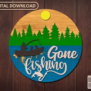 May include: A round wooden sign with a blue background and the text "Gone fishing" in white. The sign features a silhouette of a boat with three people fishing on a lake with a green forest in the background.