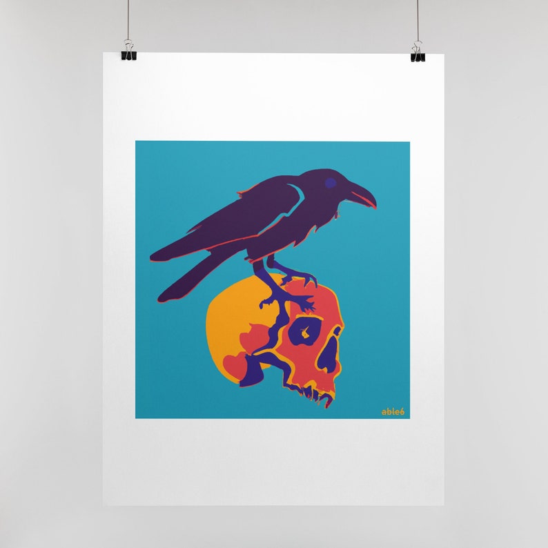 Op de afbeelding: Een rechthoekige kunstdruk met een donkerpaarse raaf die op een gele en oranje menselijke schedel zit tegen een felblauwe achtergrond. Het kunstwerk bevat de tekst "able6" in kleine gele letters in de rechterbenedenhoek.