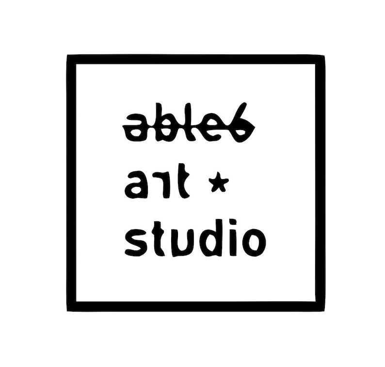 Op de afbeelding: Een vierkante zwarte rand omlijst de tekst able6 art studio in zwarte letters op een witte achtergrond. Het woord able6 is geschreven met een spiegeleffect, gevolgd door het woord art met een klein sterretje en het woord studio eronder.