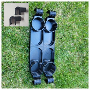 May include: Two black plastic cup holders with four cup slots. Each holder has a hook on the top for hanging.
