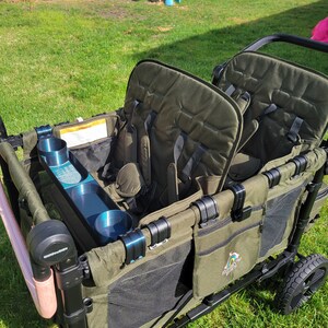 May include: A green wagon with two seats, a cup holder, and a mesh storage compartment. The wagon has a black frame and black wheels. The wagon has a logo that says "Rainbow Ridez" on the side.