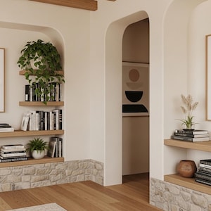 May include: Interior design featuring a neutral color palette with wooden shelves, stone accents, and framed abstract art. Books, plants, and decorative vases add to the aesthetic. The room has a modern, minimalist style.