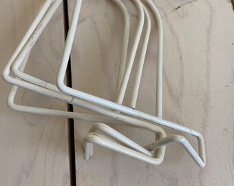 May include: A set of three off-white, U-shaped metal wire shelf dividers. Each divider features a smooth, rounded top arch and a rectangular base frame designed to slide onto a shelf, with a distinct bent wire hook at the front edge.