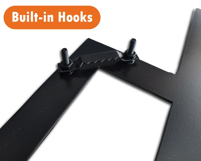 May include: Close-up of a black metal sign with two built-in hooks. The hooks are attached to the sign with screws and have a serrated edge.