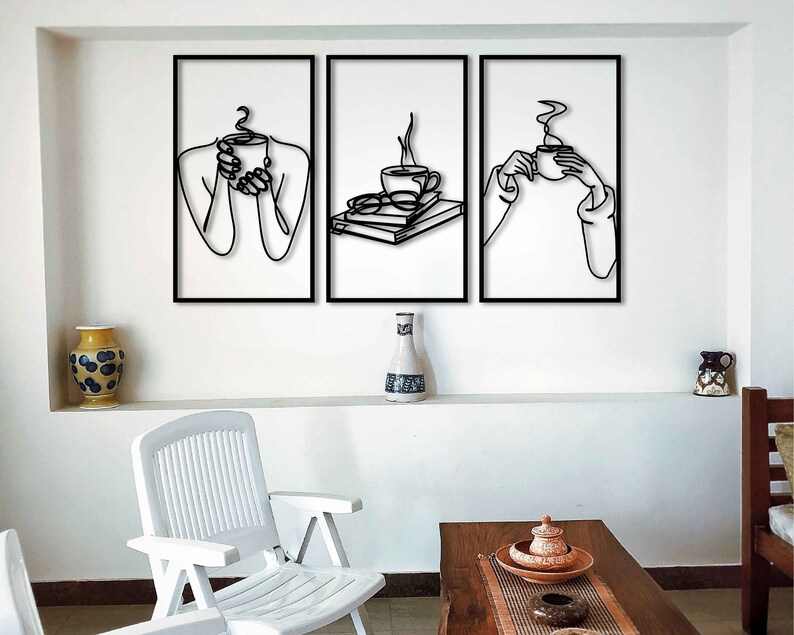 May include: Three black and white line art prints featuring a person holding a cup of coffee. The prints are framed in black and hung on a white wall.