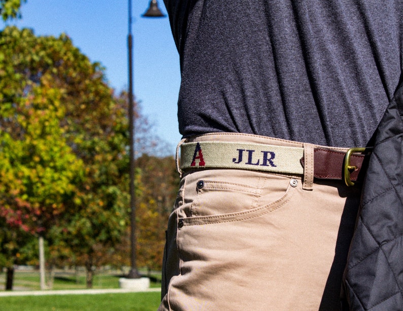 A gentlemen wearing a custom needlepoint belt with his initials added. All of our custom needlepoint belts can have initials added for no extra charge.