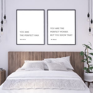May include: Two framed prints with black frames and white backgrounds. The left print reads "YOU ARE THE PERFECT MAN." The right print reads "YOU ARE THE PERFECT WOMAN, BUT YOU KNOW THAT." The prints are above a bed with white bedding.