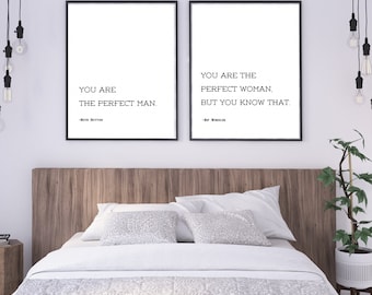 May include: Two framed prints with black frames and white backgrounds. The left print reads "YOU ARE THE PERFECT MAN." The right print reads "YOU ARE THE PERFECT WOMAN, BUT YOU KNOW THAT." The prints are above a bed with white bedding.