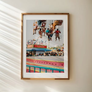 May include: A framed photograph of a vintage carnival scene with people riding a Ferris wheel. The Ferris wheel is decorated with red, white, and blue flags. The sign above the ticket booth reads "TICKETS".