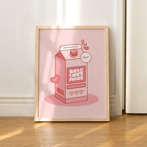 May include: A framed pink and red illustration of a carton of self-love juice. The carton has a red heart and the text "Self Love Juice" on it. The background is a light pink color.