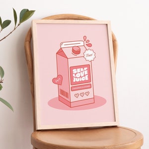 May include: A framed pink and red illustration of a carton of self-love juice. The carton has the words "Self Love Juice" and "Confidence Flavored" printed on it. The carton is sitting on a pink background.