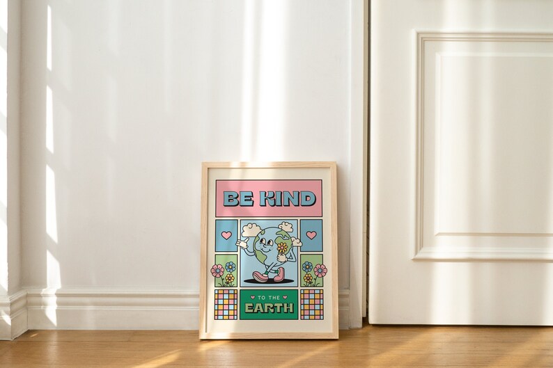 May include: A framed print with a cartoon illustration of the Earth holding flowers and the text "Be Kind to the Earth". The print has a pink, blue, and green color scheme.