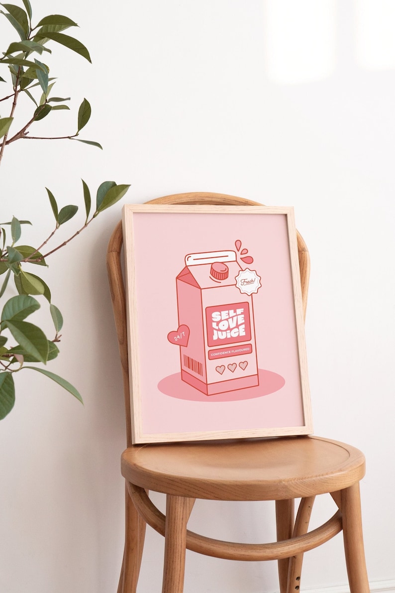 May include: A framed pink and red illustration of a carton of self-love juice. The carton has the words "Self Love Juice" and "Confidence Flavored" printed on it. The carton is sitting on a pink background.