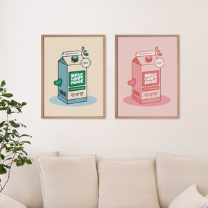 May include: Two framed prints of a cartoon illustration of a milk carton with the words "Self Love Juice" on it. The carton on the left is blue and green, and the carton on the right is pink and red.