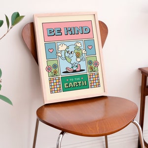 May include: A framed print with a cartoon illustration of the Earth holding a flower. The text on the print reads "Be Kind to the Earth". The print has a retro, colorful design with pink, blue, green, and yellow colors.
