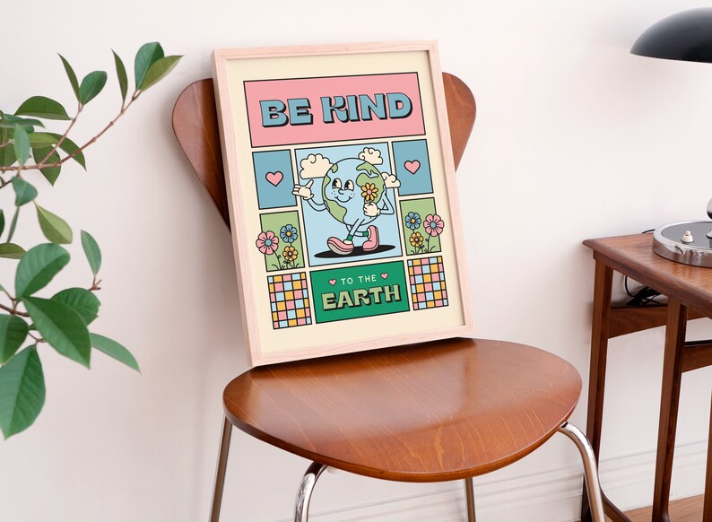 May include: A framed print with a cartoon illustration of the Earth holding a flower. The text on the print reads "Be Kind to the Earth". The print has a retro, colorful design with pink, blue, green, and yellow colors.
