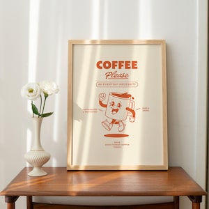 May include: A framed print with a white background and a cartoon illustration of a coffee cup with a smiling face. The text "COFFEE Please AN EVERYDAY NECESSITY" is printed in orange above the illustration. The text "CAFFEINEATED & MOTIVATED" is printed in orange on the left side of the illustration. The text "RISE & GRIND" is printed in orange on the right side of the illustration. The text "GOOD THINGS HAPPEN TODAY" is printed in orange below the illustration.