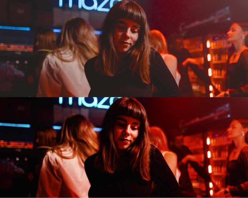 May include: Two women with long dark hair are standing in a dimly lit bar. The woman in the foreground is wearing a black turtleneck sweater and the woman in the background is wearing a white shirt. The bar is decorated with neon lights and there are other people in the background.