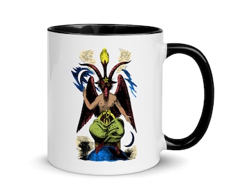 May include: White ceramic mug with a black rim and handle. The mug features a colorful illustration of a red, winged, horned figure with a yellow star on its head, sitting on a blue globe. The figure is surrounded by clouds and crescent moons.