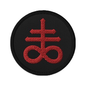 May include: Round black embroidered patch featuring a red Leviathan cross symbol. The symbol is a double cross with an infinity symbol at the bottom. The patch has a black border.