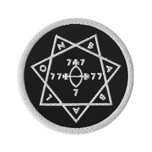Peut inclure: Un écusson brodé noir et blanc avec un motif d'étoile à sept branches. L'étoile contient les nombres 7, 777 et 717. L'écusson est entouré d'une bordure ovale blanche.