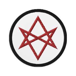 Könnte beinhalten: Ein roter, gestickter Stern mit sechs Zacken, umgeben von einem schwarzen Kreis auf weißem Hintergrund.