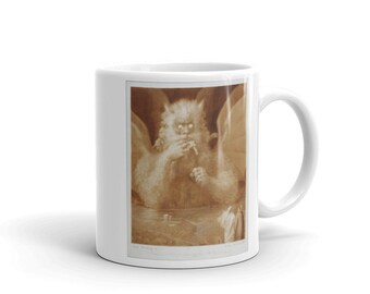 May include: A white ceramic mug with a sepia-toned image of a monstrous creature with wings, a large head, and a human-like body. The creature is depicted with its mouth open, as if it is about to speak or roar.