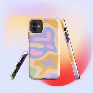 May include: A set of three phone cases with a colorful abstract design. The cases feature a pattern of flowing shapes in shades of yellow, pink, purple, and green on a beige background. The cases are shown upright and on their sides.