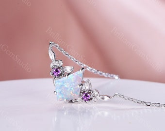 Può includere: Una collana d'argento con un ciondolo di opale bianco circondato da piccole pietre preziose viola e delicate foglie d'argento.