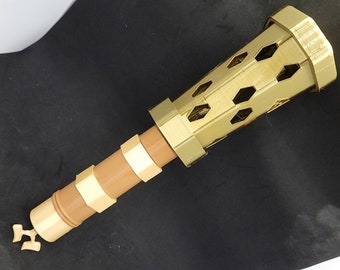 May include: A gold-colored metal torch with a decorative, geometric design. The torch has a brown wooden handle.