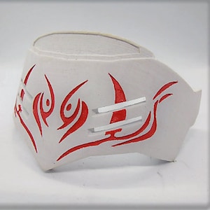 May include: White headband with a red tribal design. The design features a crescent moon and stylized flames.