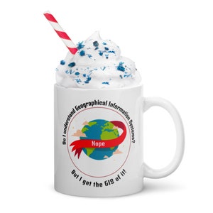 May include: White ceramic mug with a red, white, and blue design. The mug has a red ribbon with the word "Nope" on it, and the text "Do I understand Geographical Information Systems? But I get the GIS of it!" around the rim.