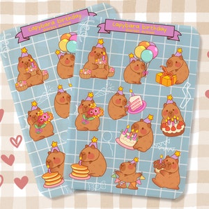 May include: A set of 16 colorful stickers featuring capybaras celebrating birthdays. The stickers feature capybaras wearing party hats, holding birthday cakes, balloons, and gifts. The stickers are on a blue background with a grid pattern.
