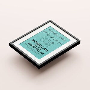 May include: A framed print with a teal background and black text. The text includes "Dua Before Eating" and "BISMILLAH WA ALA BARKATILLAH" with an illustration of a plate, knife, and fork. The frame is black.