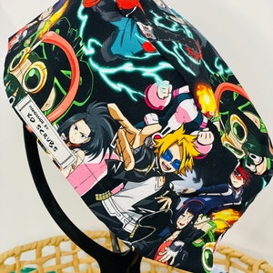 May include: Black scrub hat with a colourful anime print featuring characters from the show My Hero Academia. The hat has a label that says "Handmade by KD Scrubs".