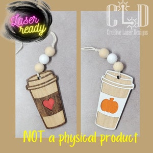 Puede incluir: Dos adornos de taza de café de madera cortados con láser con una cuerda de cuentas de madera. Una taza tiene un corazón rojo y la otra una calabaza naranja. El texto "Laser ready" es visible en la esquina superior izquierda de la imagen.