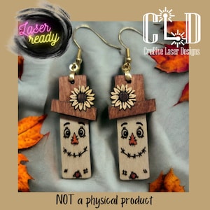 May include: A pair of wooden earrings shaped like scarecrows with brown hats and sunflowers. The earrings are laser cut and ready to be assembled.