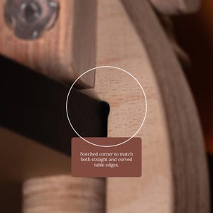 May include: A light-colored wooden component featuring a dark, recessed notched corner designed to align with table edges. A brown rectangular label with white text reads: Notched corner to match both straight and curved table edges.