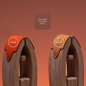 May include: Two wooden stitching ponies with leather accents. One features a bright orange textured leather top, and the other features a natural tan leather top. The text "Two colors to choose from." is centered above the two tools.