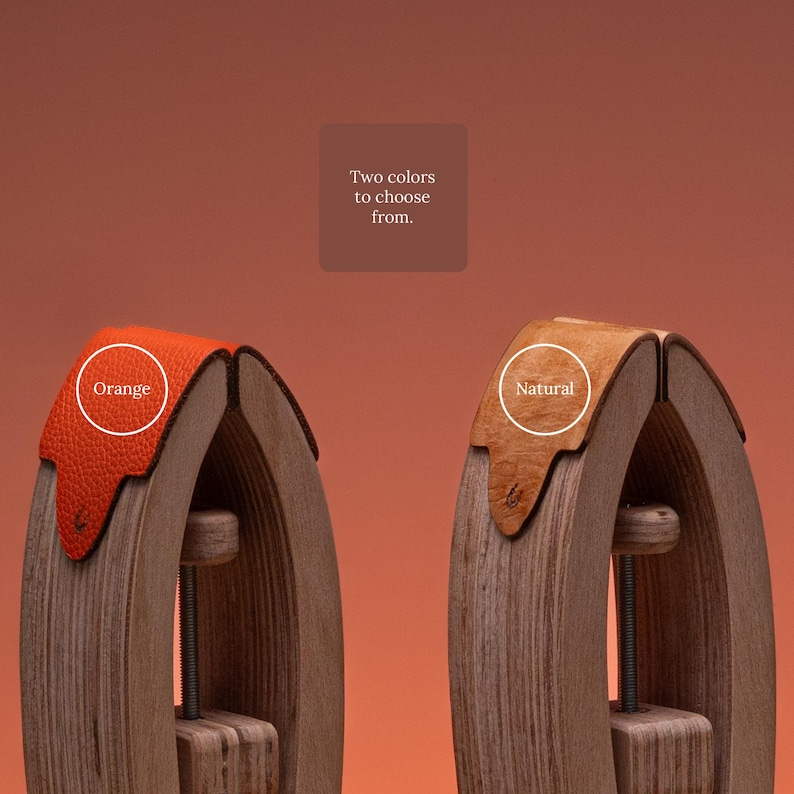 May include: Two wooden stitching ponies with leather accents. One features a bright orange textured leather top, and the other features a natural tan leather top. The text "Two colors to choose from." is centered above the two tools.
