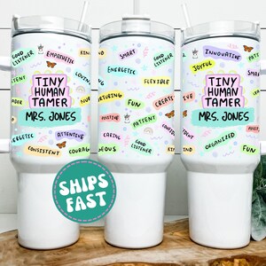 May include: White tumbler with a handle, lid, and straw. The tumbler is decorated with colorful words like "Kind," "Fun," and "Good Listener." The text "TINY HUMAN TAMER MRS. JONES" is also featured.