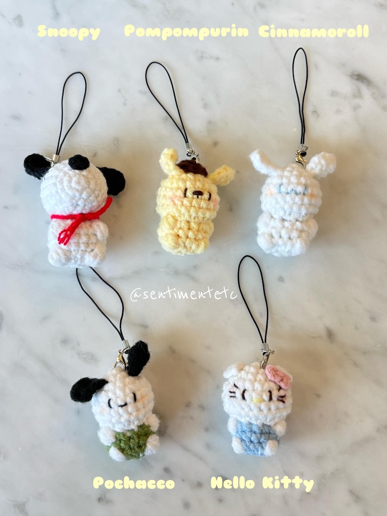 May include: Crocheted character charms featuring Snoopy, Pompompurin, Cinnamoroll, Pochacco, and Hello Kitty. Each charm is white, yellow, or blue, with black accents and a black lanyard. The text "Snoopy", "Pompompurin", "Cinnamoroll", "Pochacco", and "Hello Kitty" is displayed.