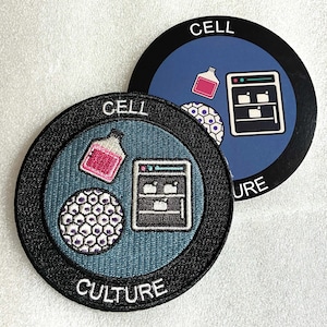 以下が含まれることがあります： CELL CULTUREという文字が入った円形の刺繍ワッペンと、それとお揃いの円形ステッカー。青い背景に黒い縁取りが施され、ピンク色の液体が入ったフラスコ、白い細胞の塊、黒い実験用インキュベーターのアイコンがデザインされています。