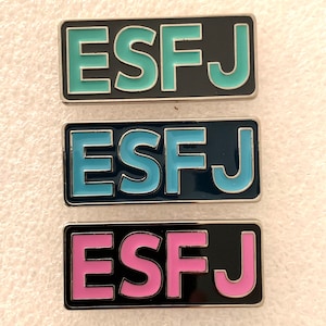 Può includere: Tre spille in smalto con le lettere "ESFJ" in diversi colori. La spilla superiore ha lettere blu chiaro su sfondo nero. La spilla centrale ha lettere blu su sfondo blu scuro. La spilla inferiore ha lettere rosa su sfondo nero.